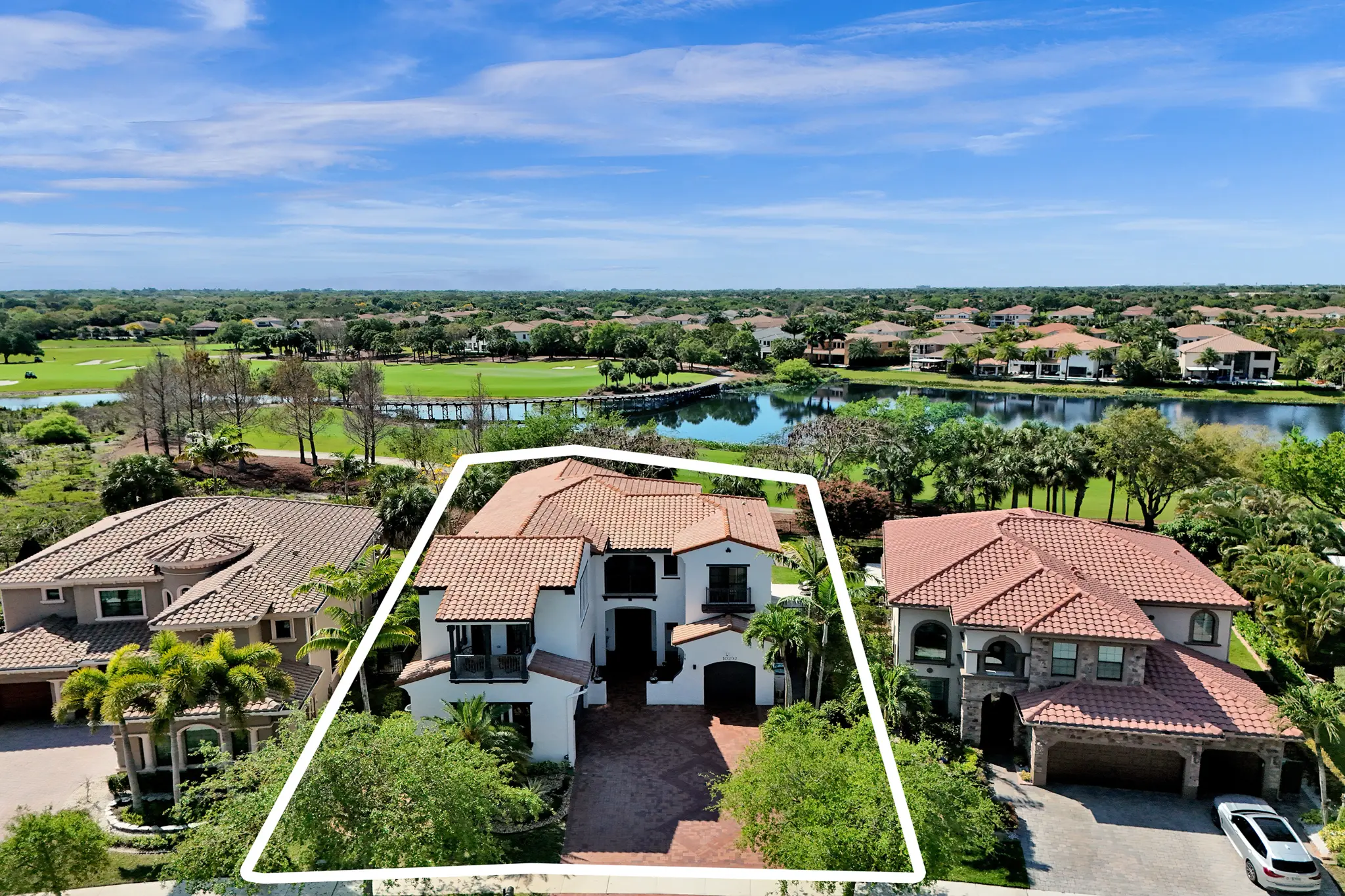 Aerial view of 10292 Emerson St on the Parkland Golf & Country Club course with lake and bridge views